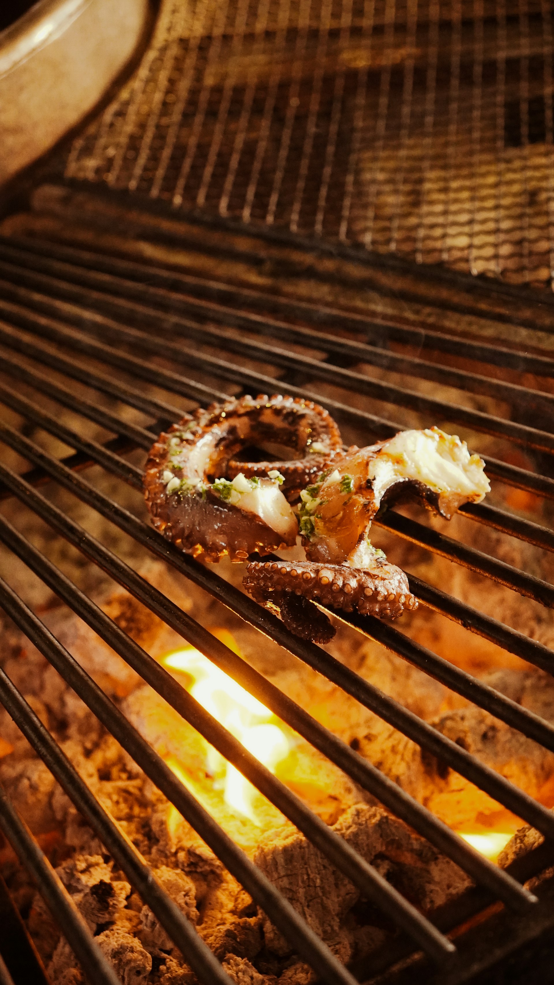 Pulpo asándose sobre brasas encendidas