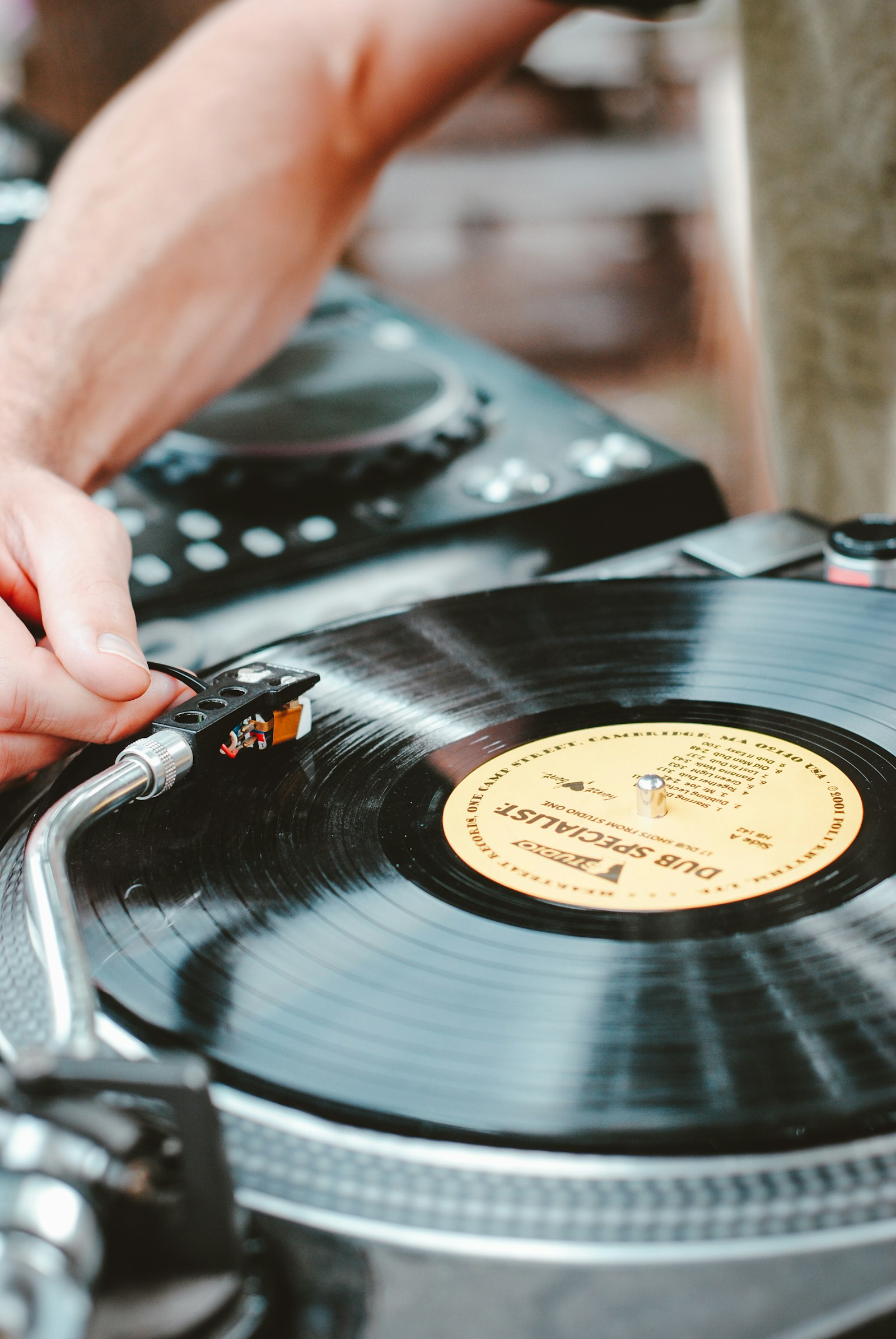 Mano colocando la aguja sobre un disco de vinilo en la tornamesa